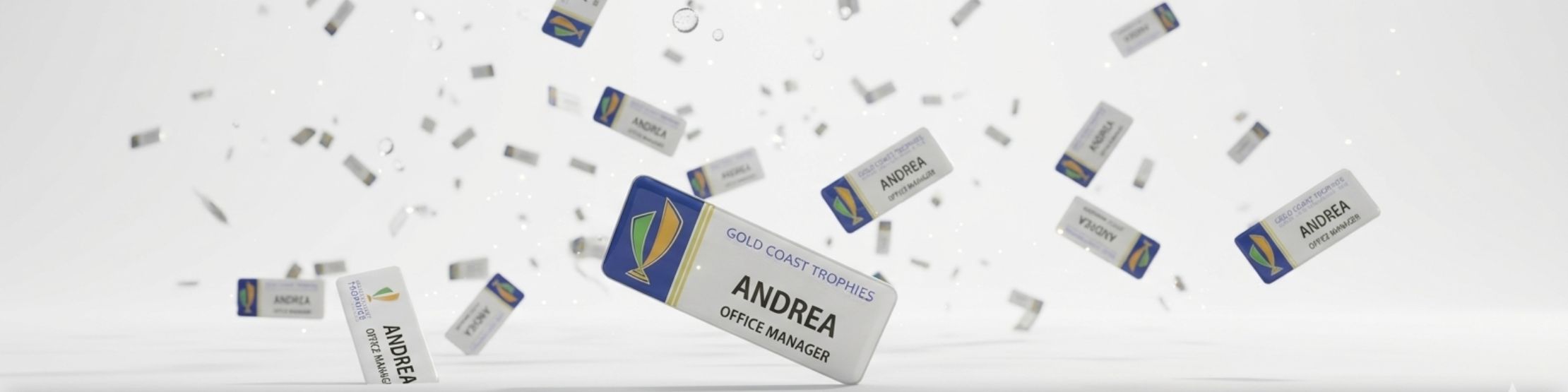 A dynamic 3D rendering of multiple custom Gold Coast Trophies name badges raining down against a bright white background.